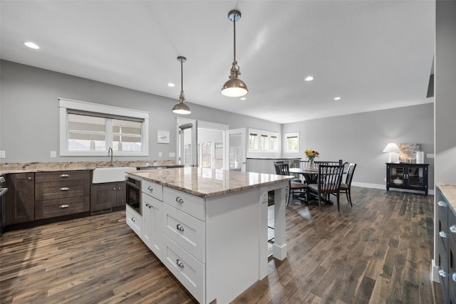 6318 Rapids Ridge Rd NE, Cedar Rapids, IA 52411 - kitchen featuring a sink, dark brown cabinetry, dark wood-type flooring, a center island, and recessed lighting