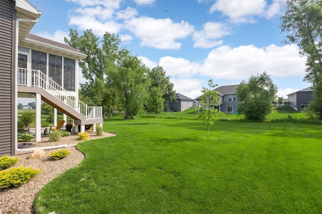 6318 Rapids Ridge Rd NE, Cedar Rapids, IA 52411 - view of grassy yard featuring a sunroom, stairs, and a residential view