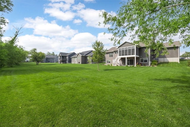 6318 Rapids Ridge Rd NE, Cedar Rapids, IA 52411 - view of grassy yard featuring a sunroom, stairway, and a residential view
