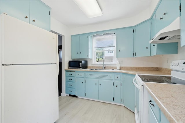 32 29th Ave SW, Cedar Rapids, IA 52404 - kitchen with white appliances, a sink, blue cabinetry, under cabinet range hood, and light countertops