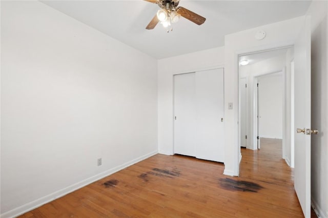 32 29th Ave SW, Cedar Rapids, IA 52404 - unfurnished bedroom featuring baseboards, light wood-style floors, a closet, and a ceiling fan
