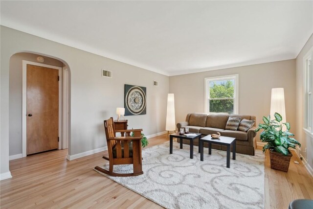 1252 29th St, Cedar Rapids, IA 52402 - living room featuring arched walkways, light wood-style flooring, and baseboards