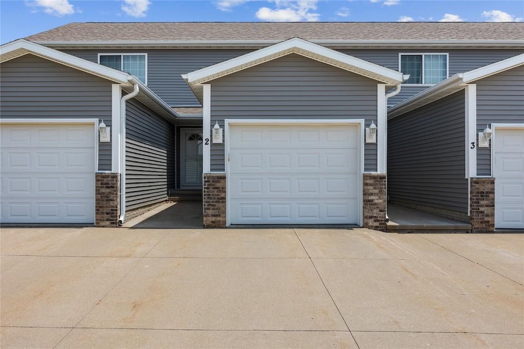 5937 Muirfield Dr SW Unit 2, Cedar Rapids, IA 52404 - view of front of home with concrete driveway, a garage, and brick siding