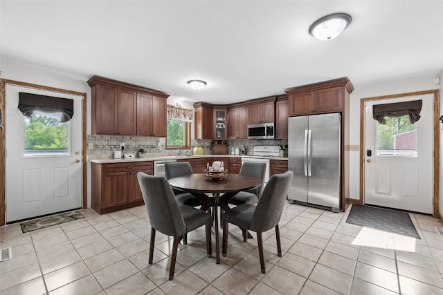 4427 J St SW, Cedar Rapids, IA 52404 - kitchen featuring appliances with stainless steel finishes, light countertops, backsplash, and light tile patterned floors