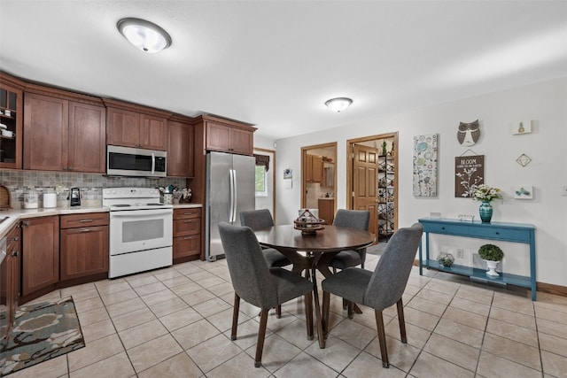 4427 J St SW, Cedar Rapids, IA 52404 - kitchen featuring stainless steel appliances, light countertops, light tile patterned floors, and tasteful backsplash
