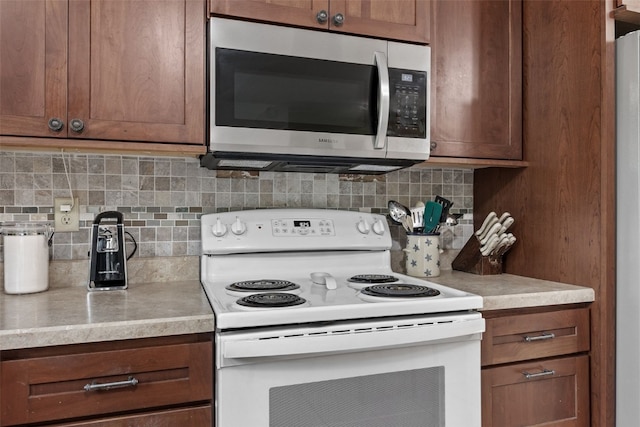4427 J St SW, Cedar Rapids, IA 52404 - kitchen with stainless steel microwave, white range with electric stovetop, tasteful backsplash, and light countertops