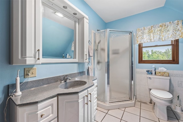 4427 J St SW, Cedar Rapids, IA 52404 - bathroom featuring tile patterned flooring, vanity, toilet, a shower stall, and tile walls
