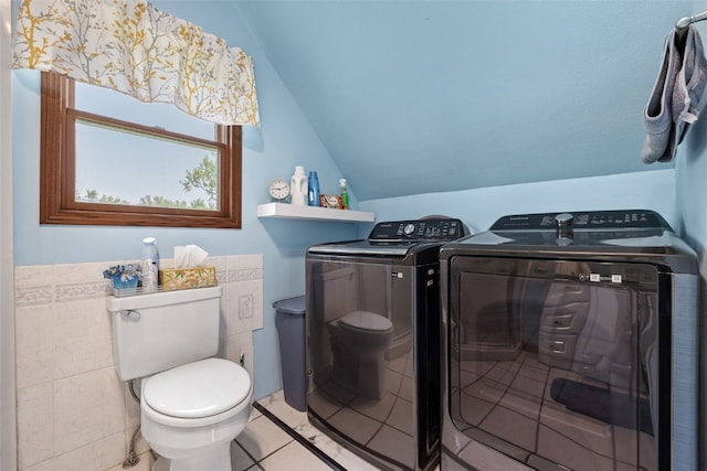 4427 J St SW, Cedar Rapids, IA 52404 - half bathroom featuring toilet, washer and clothes dryer, lofted ceiling, tile patterned flooring, and tile walls