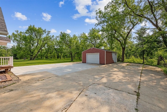 4427 J St SW, Cedar Rapids, IA 52404 - view of patio featuring a garage, an outbuilding, and concrete driveway