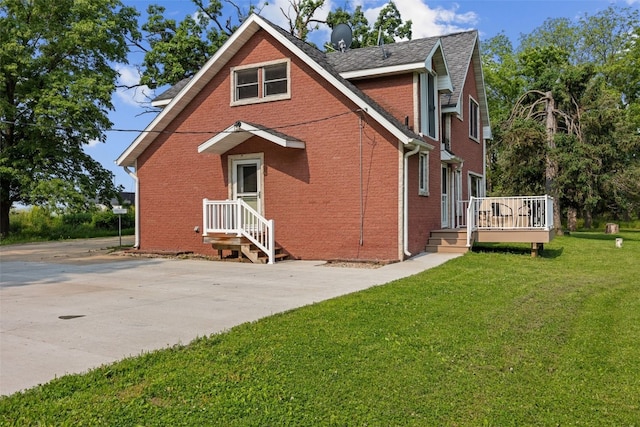 4427 J St SW, Cedar Rapids, IA 52404 - back of property with brick siding, a lawn, and a wooden deck