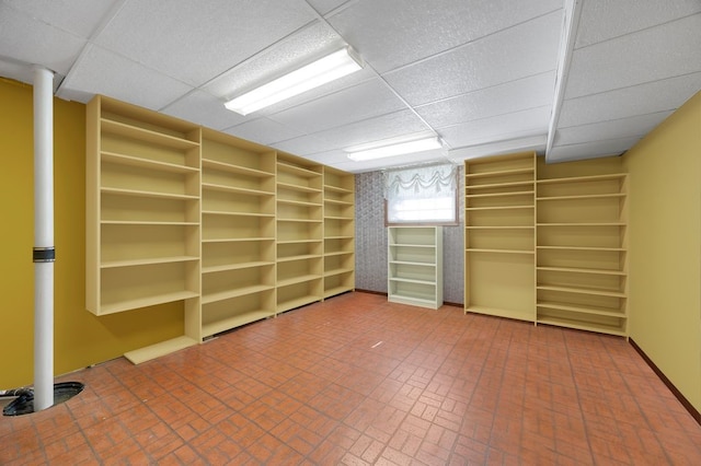 6909 Kent Dr NE, Cedar Rapids, IA 52402 - basement featuring brick patterned flooring, a paneled ceiling, and baseboards