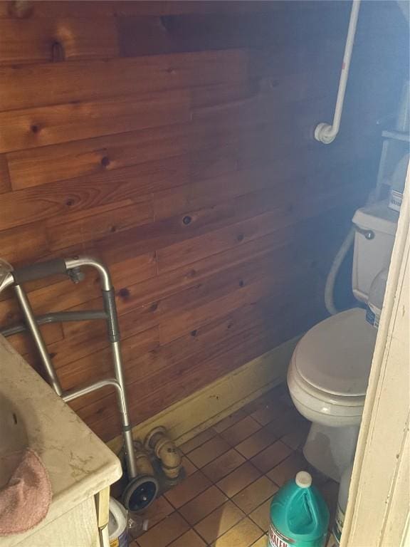 321 E 2nd St, Washington, IA 52353 - bathroom with toilet, tile patterned flooring, vanity, and wooden walls