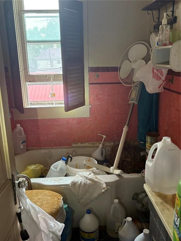 321 E 2nd St, Washington, IA 52353 - bathroom with tile walls, wainscoting, and a bathtub