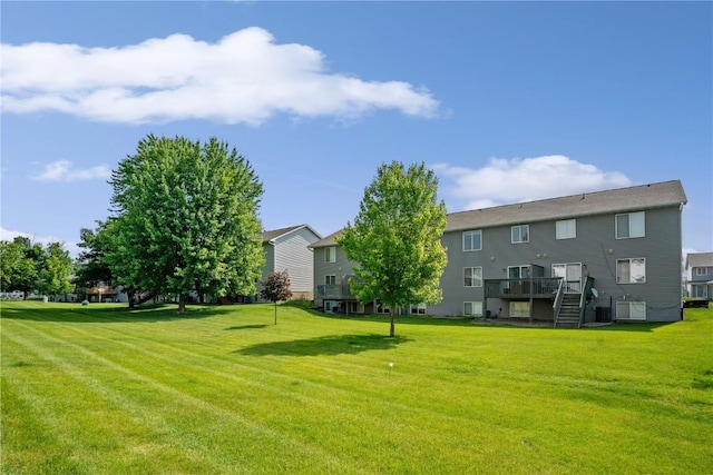 2710 Pheasant Ridge Ct, Marion, IA 52302 - view of grassy yard with stairway, a deck, and central AC unit