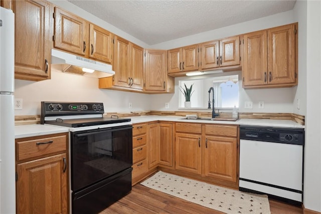 2710 Pheasant Ridge Ct, Marion, IA 52302 - kitchen featuring white appliances, under cabinet range hood, a sink, light countertops, and a textured ceiling