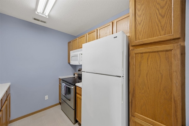 3511 E Ave NW Unit D, Cedar Rapids, IA 52405 - kitchen with white appliances, light flooring, light countertops, a textured ceiling, and baseboards