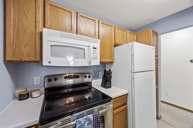 3511 E Ave NW Unit D, Cedar Rapids, IA 52405 - kitchen featuring white appliances, light countertops, baseboards, and a textured ceiling