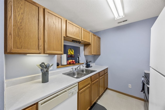 3511 E Ave NW Unit D, Cedar Rapids, IA 52405 - kitchen featuring white appliances, a sink, light countertops, a textured ceiling, and baseboards