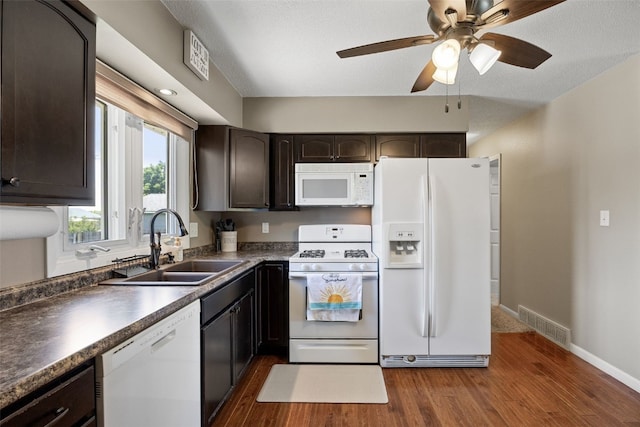 2985 4th St, Marion, IA 52302 - kitchen featuring white appliances, a sink, dark brown cabinets, dark wood-style floors, and dark countertops