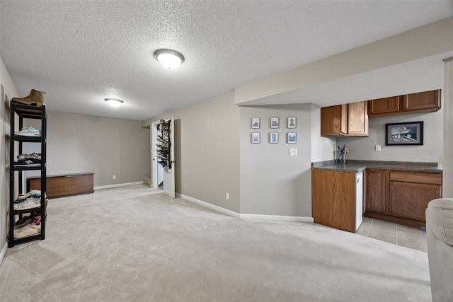 2985 4th St, Marion, IA 52302 - kitchen with a textured ceiling, brown cabinetry, open floor plan, baseboards, and light carpet