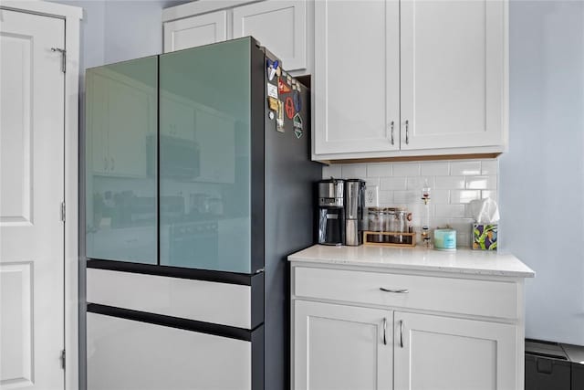 2890 Meadow Ct, Hiawatha, IA 52233 - kitchen with freestanding refrigerator, white cabinets, backsplash, and light stone countertops