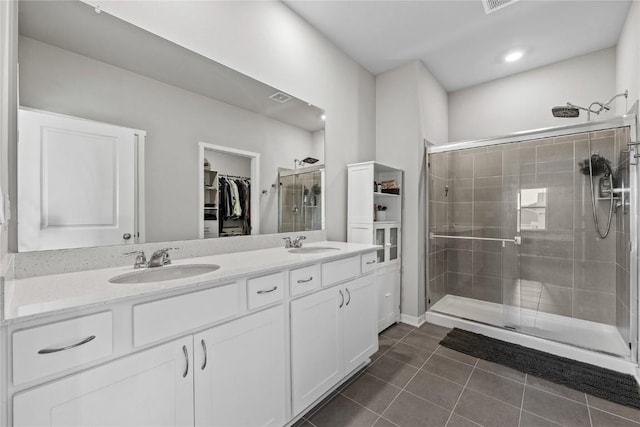 2890 Meadow Ct, Hiawatha, IA 52233 - bathroom featuring a shower stall, a spacious closet, double vanity, and tile patterned floors