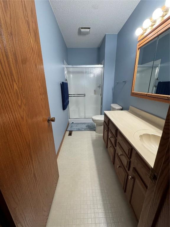 4610 Westchester Dr NE Unit A, Cedar Rapids, IA 52402 - full bath featuring a shower stall, vanity, toilet, and a textured ceiling