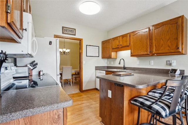 4610 Westchester Dr NE Unit A, Cedar Rapids, IA 52402 - kitchen featuring dishwasher, a peninsula, a sink, a kitchen breakfast bar, and brown cabinets