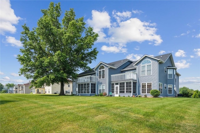 4610 Westchester Dr NE Unit A, Cedar Rapids, IA 52402 - rear view of property with a balcony, a sunroom, and a yard