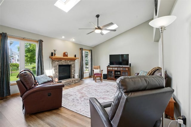 7025 Walden Rd NE, Cedar Rapids, IA 52402 - living room with a brick fireplace, light wood-type flooring, a skylight, ceiling fan, and recessed lighting