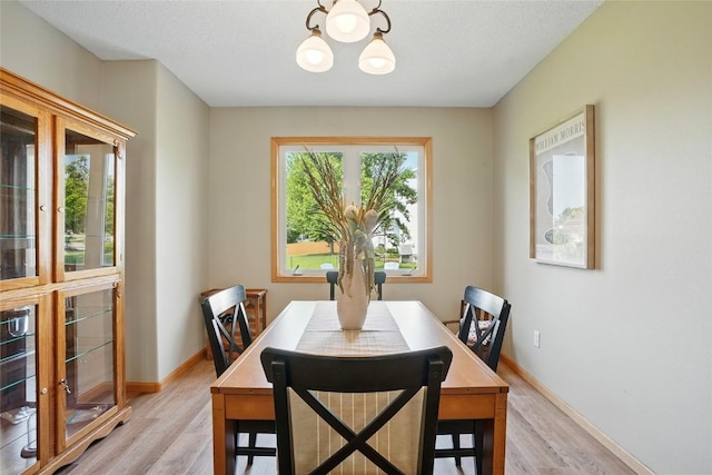7025 Walden Rd NE, Cedar Rapids, IA 52402 - dining space with light wood-style flooring, a chandelier, and baseboards