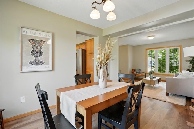 7025 Walden Rd NE, Cedar Rapids, IA 52402 - dining area with a chandelier, light wood-type flooring, and baseboards