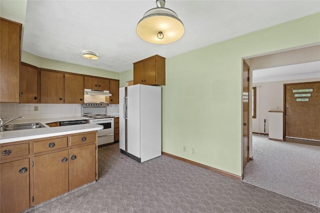 2430 Victoria Dr SW, Cedar Rapids, IA 52404 - kitchen featuring white appliances, under cabinet range hood, a sink, light carpet, and light countertops