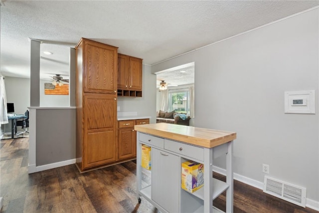 1026 Eisenhower Rd, Hiawatha, IA 52233 - kitchen with a ceiling fan, butcher block counters, a textured ceiling, dark wood-style floors, and brown cabinets