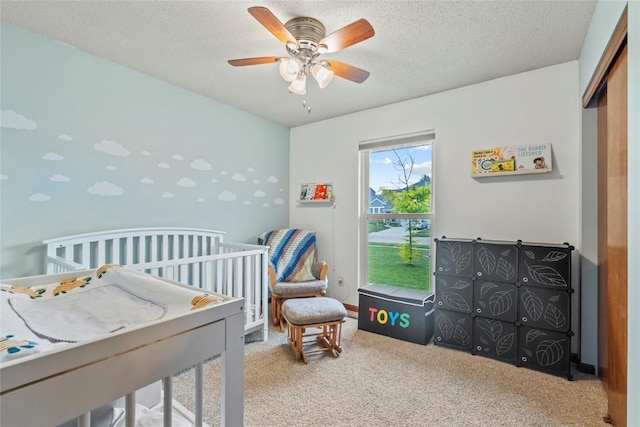 6813 Terrazzo Dr NW, Cedar Rapids, IA 52405 - bedroom with carpet, a textured ceiling, ceiling fan, a crib, and a closet