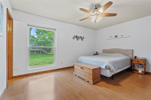 6813 Terrazzo Dr NW, Cedar Rapids, IA 52405 - bedroom featuring wood finished floors, baseboards, ceiling fan, and a textured ceiling