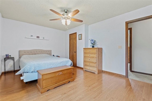 6813 Terrazzo Dr NW, Cedar Rapids, IA 52405 - bedroom with light wood finished floors, baseboards, a textured ceiling, and ceiling fan