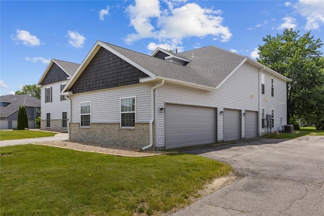 4555 Westchester Dr NE Unit A, Cedar Rapids, IA 52402 - view of side of home with cooling unit, a yard, driveway, an attached garage, and brick siding