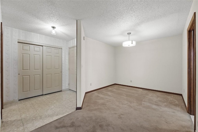 4111 Blue Jay Dr NE Unit A, Cedar Rapids, IA 52402 - unfurnished bedroom featuring baseboards, carpet, a closet, and a textured ceiling