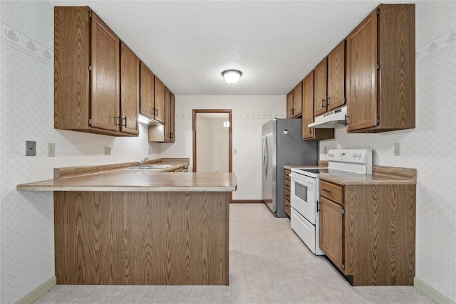 4111 Blue Jay Dr NE Unit A, Cedar Rapids, IA 52402 - kitchen with white electric range oven, under cabinet range hood, a sink, a peninsula, and wallpapered walls
