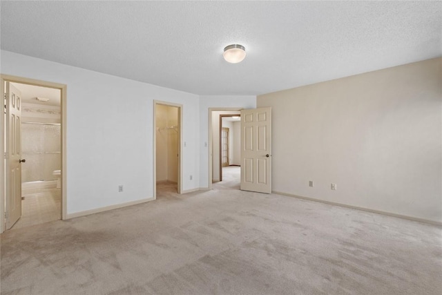 4111 Blue Jay Dr NE Unit A, Cedar Rapids, IA 52402 - unfurnished bedroom with a walk in closet, carpet flooring, baseboards, a closet, and ensuite bathroom