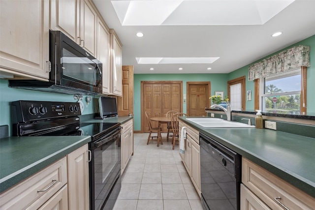 4324 C Ave NE, Cedar Rapids, IA 52402 - kitchen featuring black appliances, a skylight, a sink, dark countertops, and light tile patterned flooring