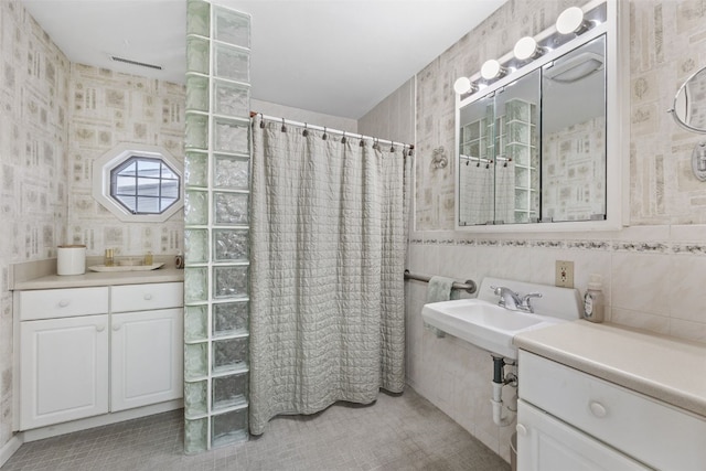 4324 C Ave NE, Cedar Rapids, IA 52402 - bathroom featuring a shower with curtain, tile patterned floors, wallpapered walls, and tile walls