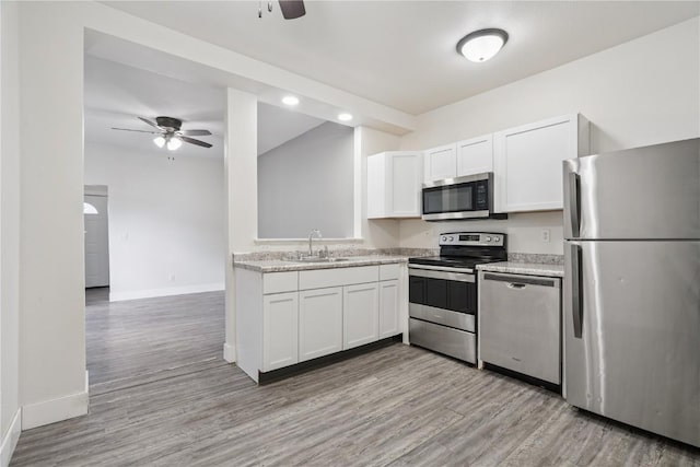 208 Northgate St, Shellsburg, IA 52332 - kitchen featuring appliances with stainless steel finishes, a ceiling fan, white cabinets, light wood-style floors, and recessed lighting