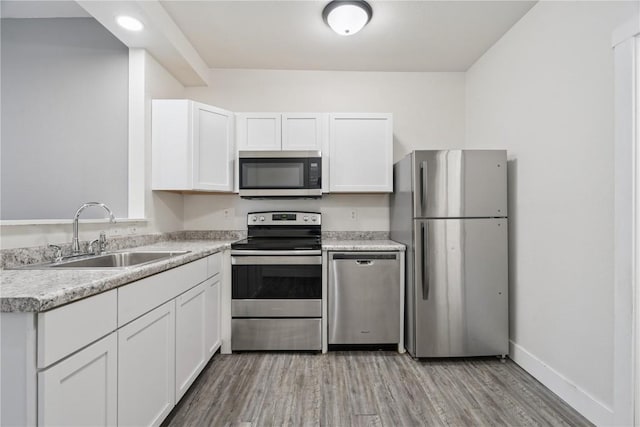 208 Northgate St, Shellsburg, IA 52332 - kitchen featuring appliances with stainless steel finishes, light wood-type flooring, white cabinetry, and light countertops