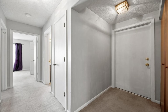 2131 1st Ave SE Unit 116, Cedar Rapids, IA 52403 - hall with light colored carpet, a textured ceiling, and baseboards