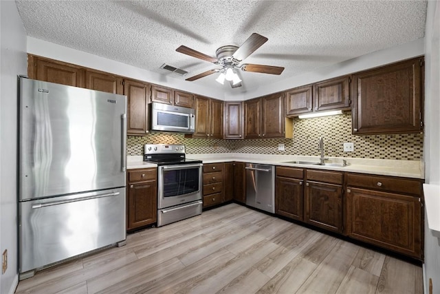 2131 1st Ave SE Unit 116, Cedar Rapids, IA 52403 - kitchen featuring appliances with stainless steel finishes, a sink, light countertops, a ceiling fan, and decorative backsplash