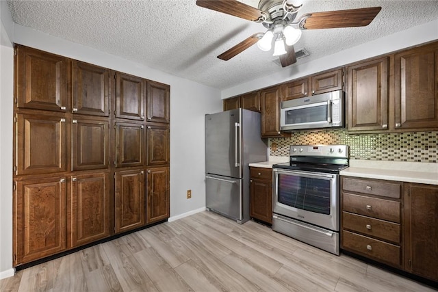 2131 1st Ave SE Unit 116, Cedar Rapids, IA 52403 - kitchen featuring appliances with stainless steel finishes, light countertops, a textured ceiling, light wood-style floors, and ceiling fan