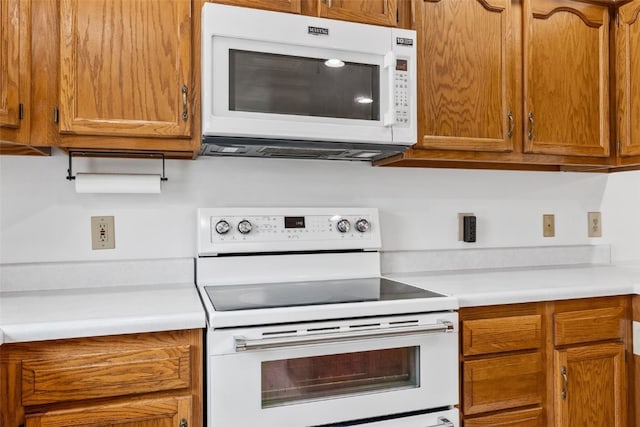 1782 Baker Ave, West Branch, IA 52358 - kitchen with white appliances, light countertops, and brown cabinets