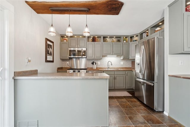 452 Lewellen Dr NW, Cedar Rapids, IA 52405 - kitchen with appliances with stainless steel finishes, a sink, gray cabinetry, a peninsula, and decorative backsplash